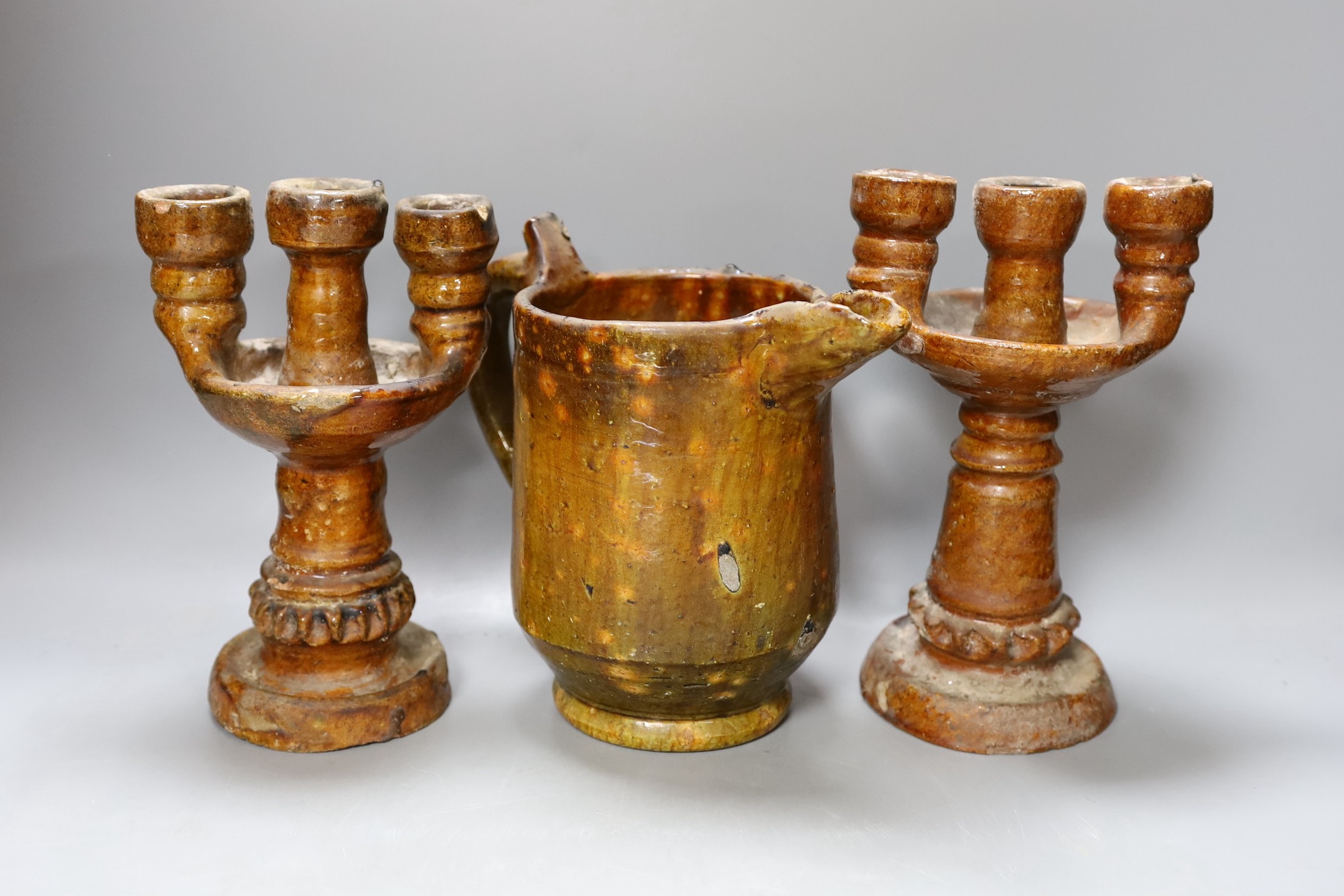 A 19th century rustic pottery jug and a pair of candelabra, 23cm